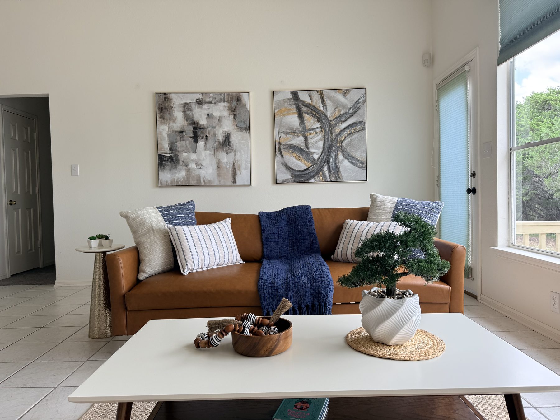 Highland Property Staging install — Sucha living room with leather sofa and paired abstract art